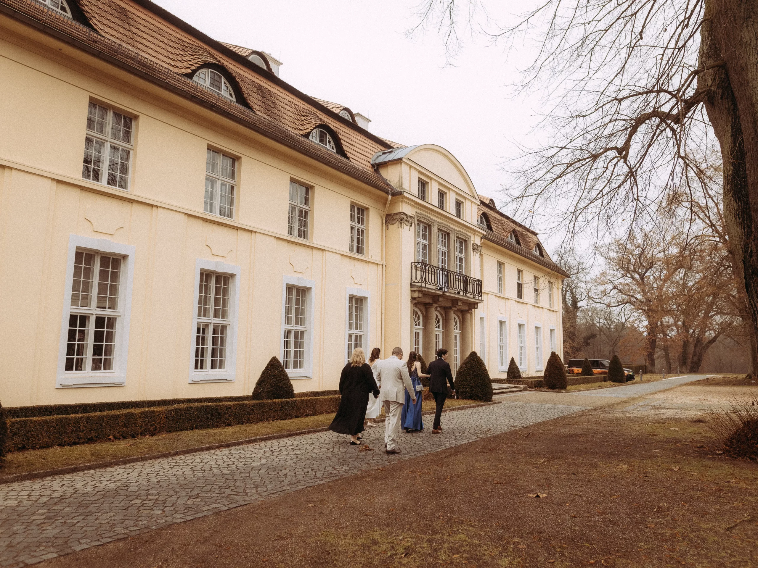Gruppe geht auf Schloss zu. Architektur im Herbst.
