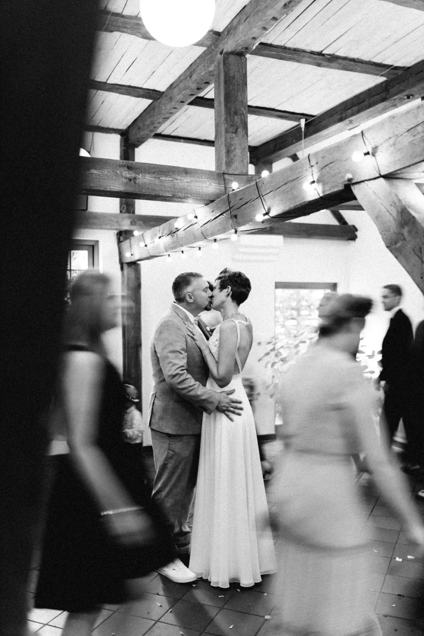 Ein Brautpaar küsst sich innig während seiner Hochzeitsfeier in MV. Der Hochzeitsfotograf in MV hat diesen besonderen Moment eingefangen. Gäste tanzen verschwommen im Hintergrund.