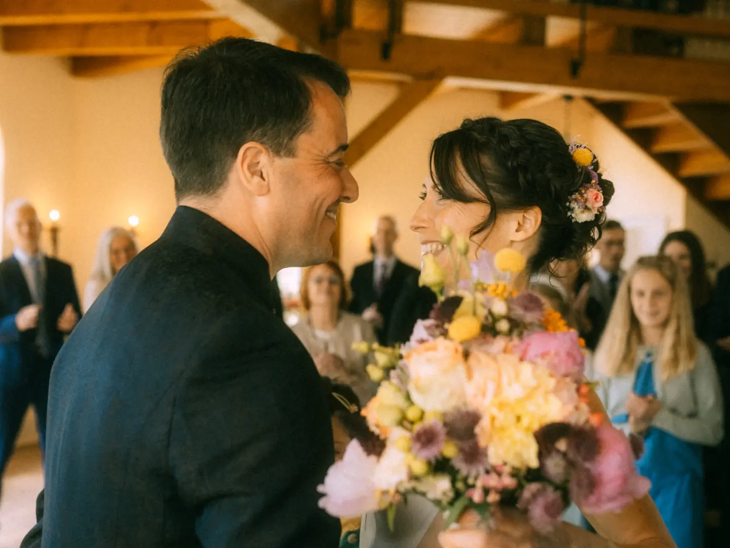 Ein glückliches Brautpaar blickt sich während der Zeremonie in einer rustikalen Location liebevoll an, während die Braut einen farbenfrohen Blumenstrauß hält. Als Lovestory Fotograf in Schwerin und MV fange ich solche intimen, emotionalen Momente für die Ewigkeit ein.